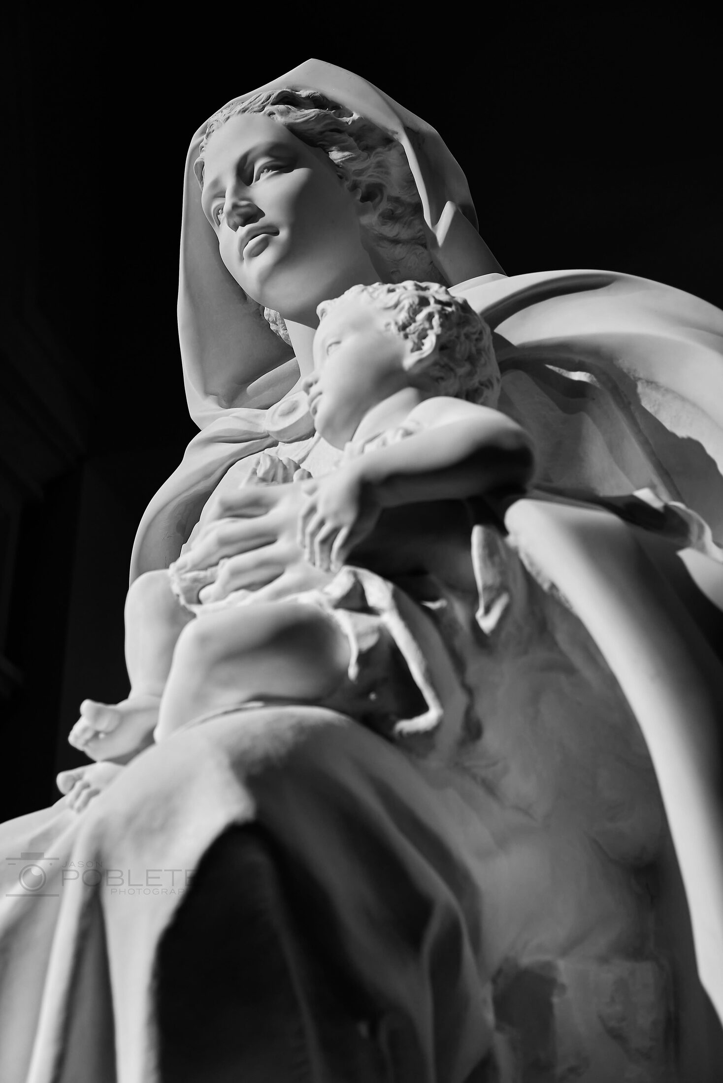 A close view of a weathered statue holding a child.