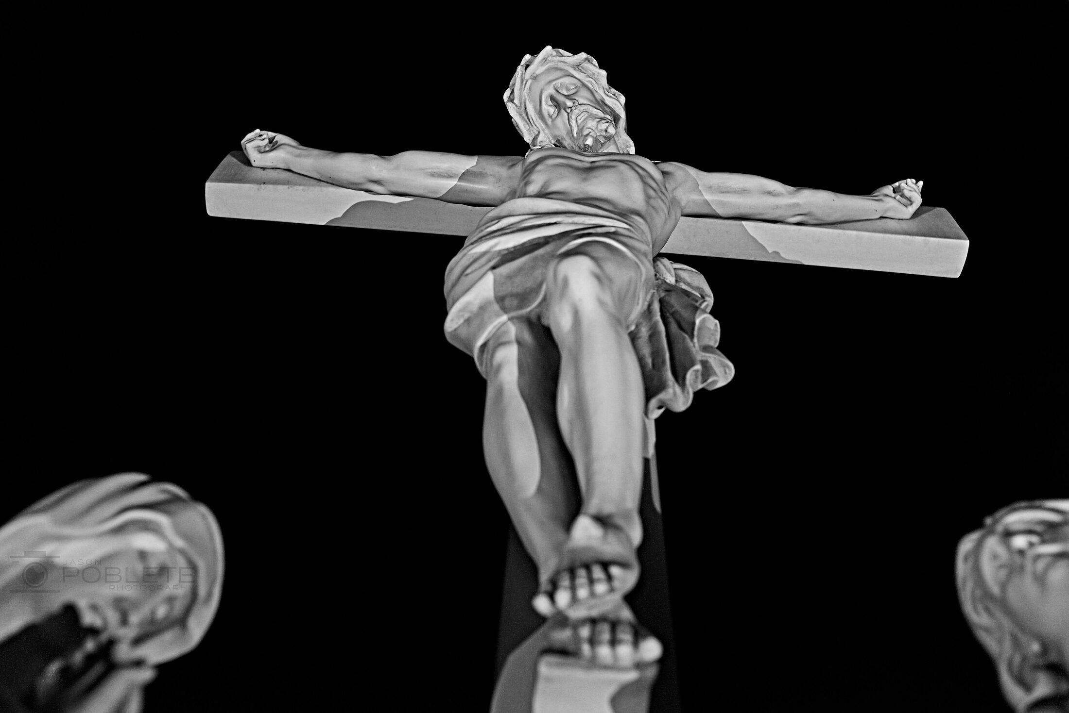 A crucifix is isolated against a black sky.