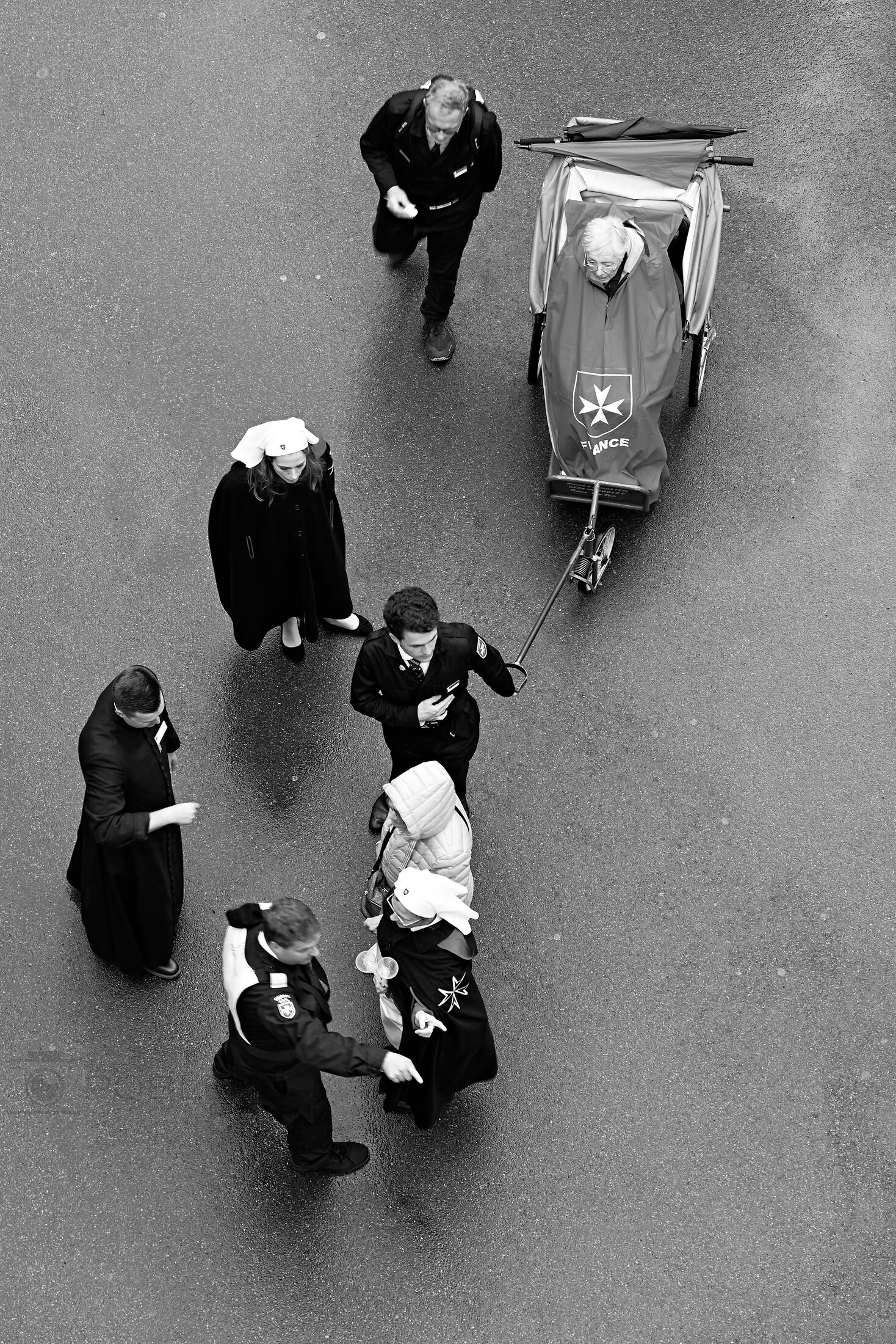 A small group of people is seen from above on a paved walkway.
