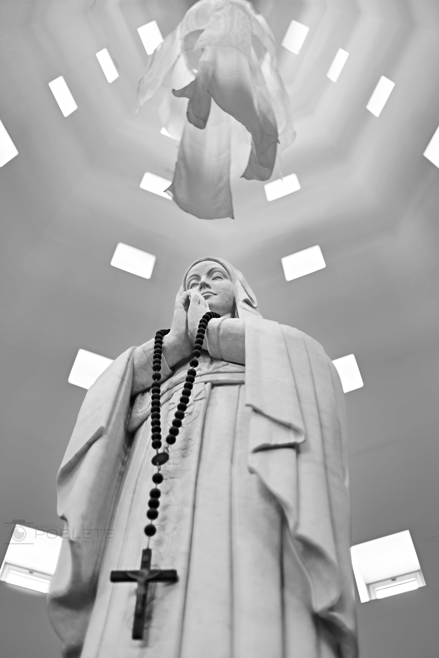 A crucifix hangs beneath geometric ceiling lights.