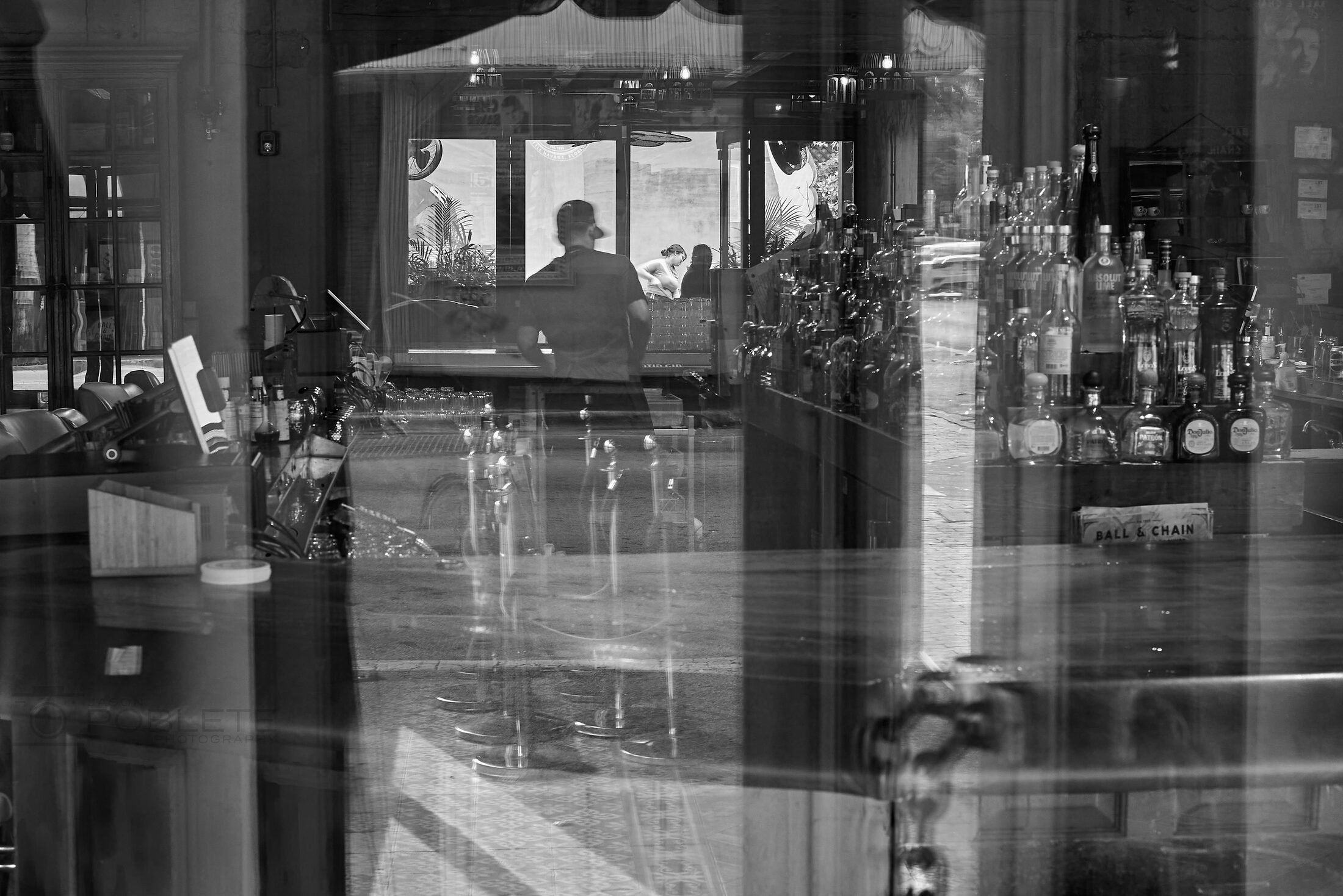 A quiet shop interior is layered with reflections from the street.
