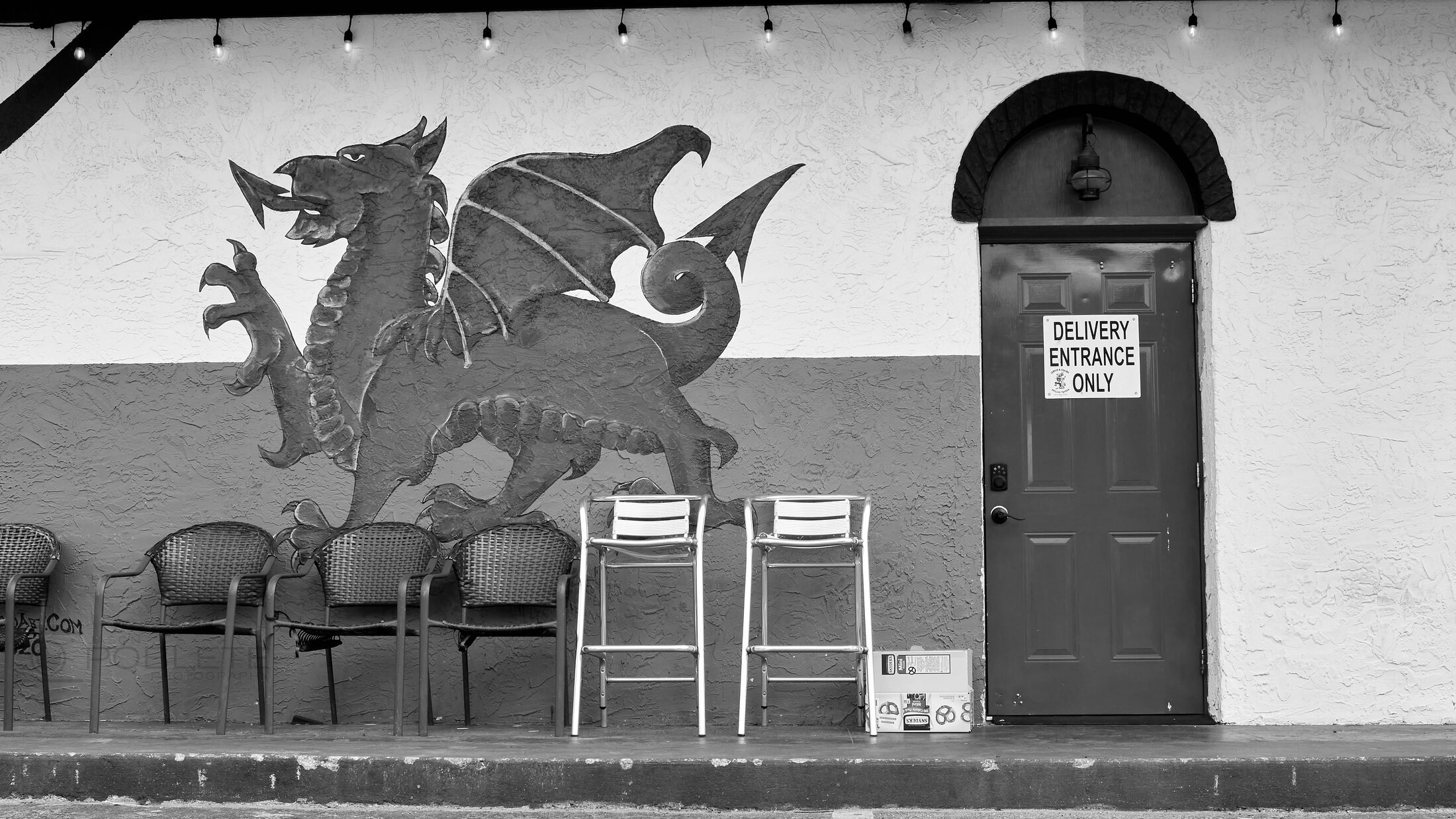 A bus stop and post box stand beside a painted dragon mural.