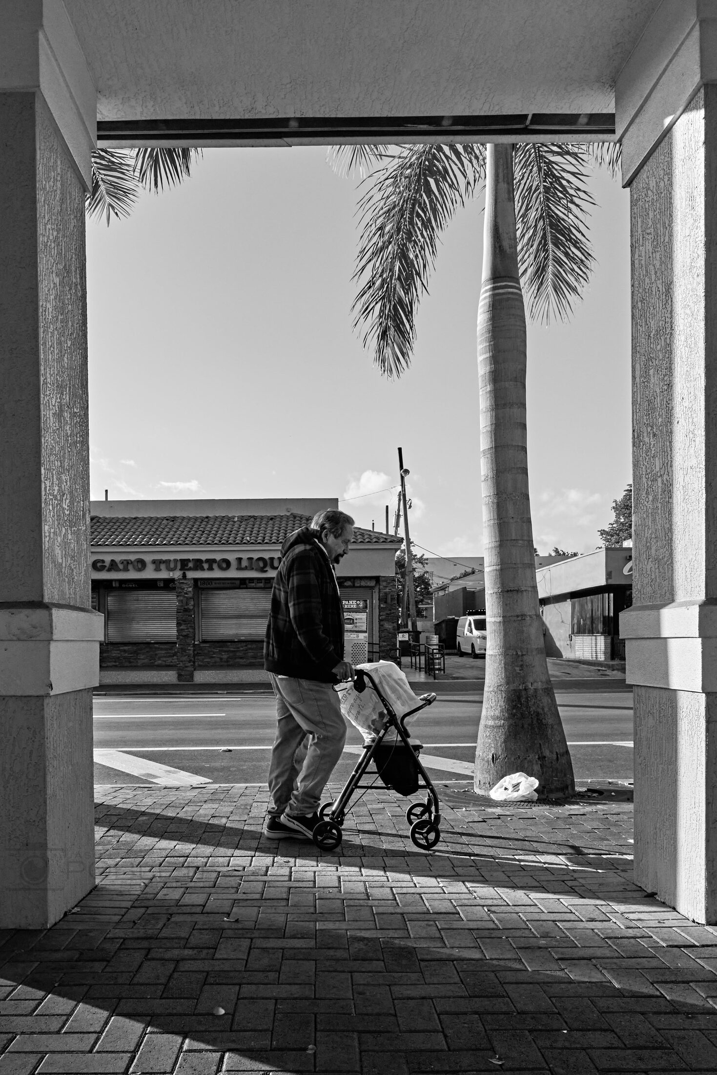 A distant figure is framed by an open doorway overlooking water.