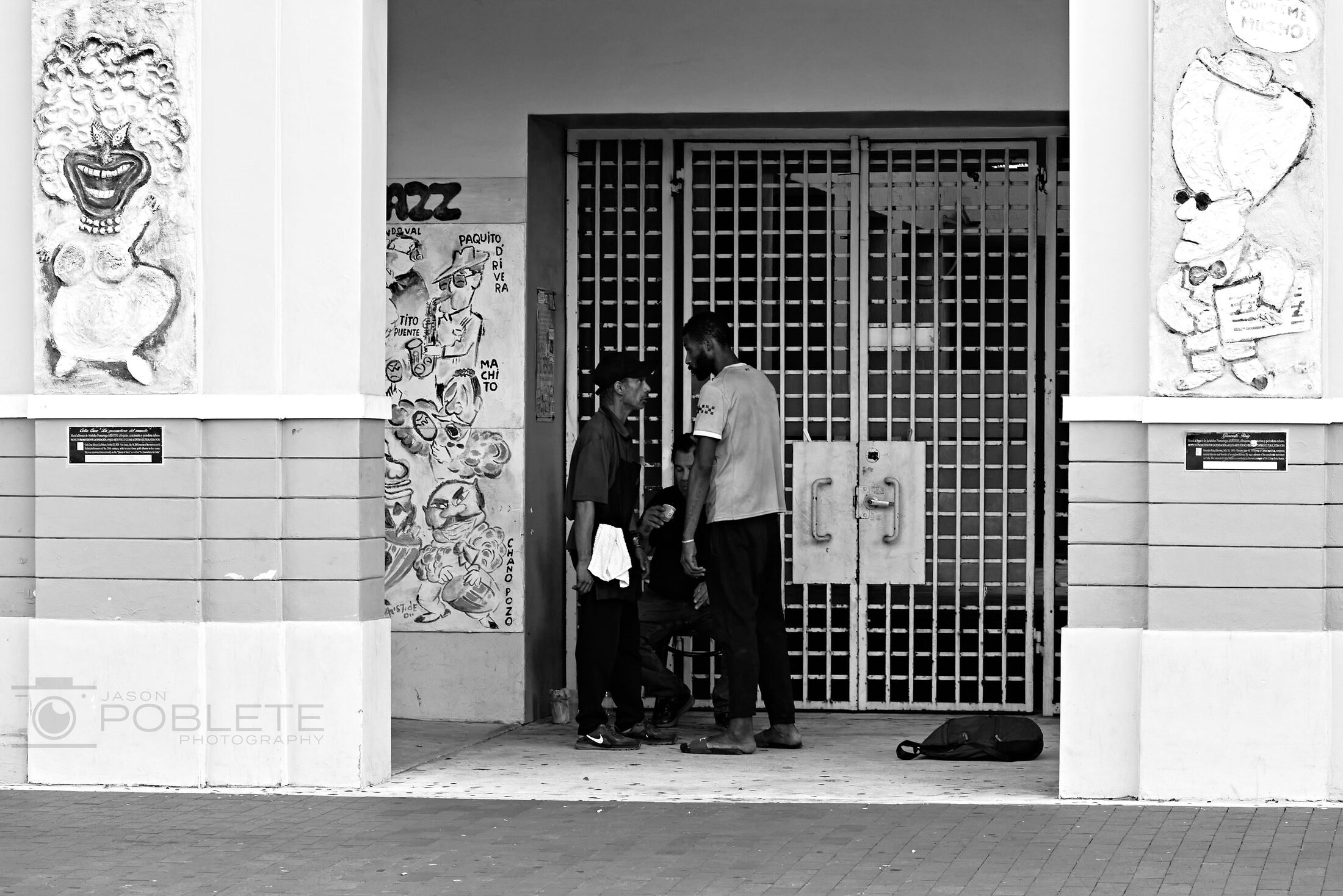 A person stands in the doorway of a tiled storefront.