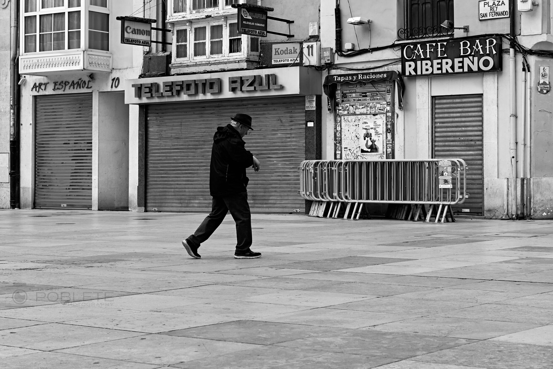 A lone pedestrian crosses a broad city street.