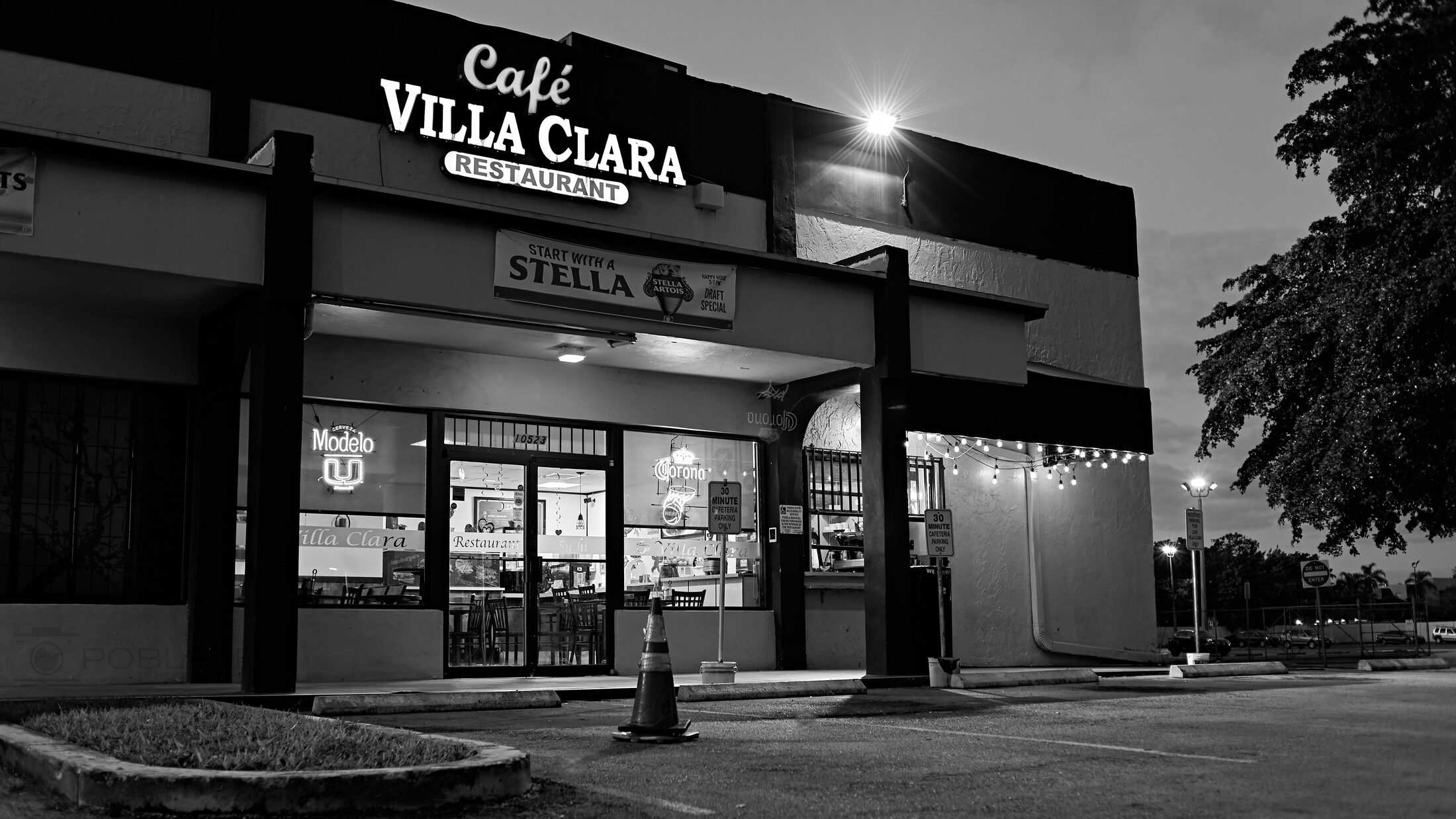 A corner café glows against the dark street.