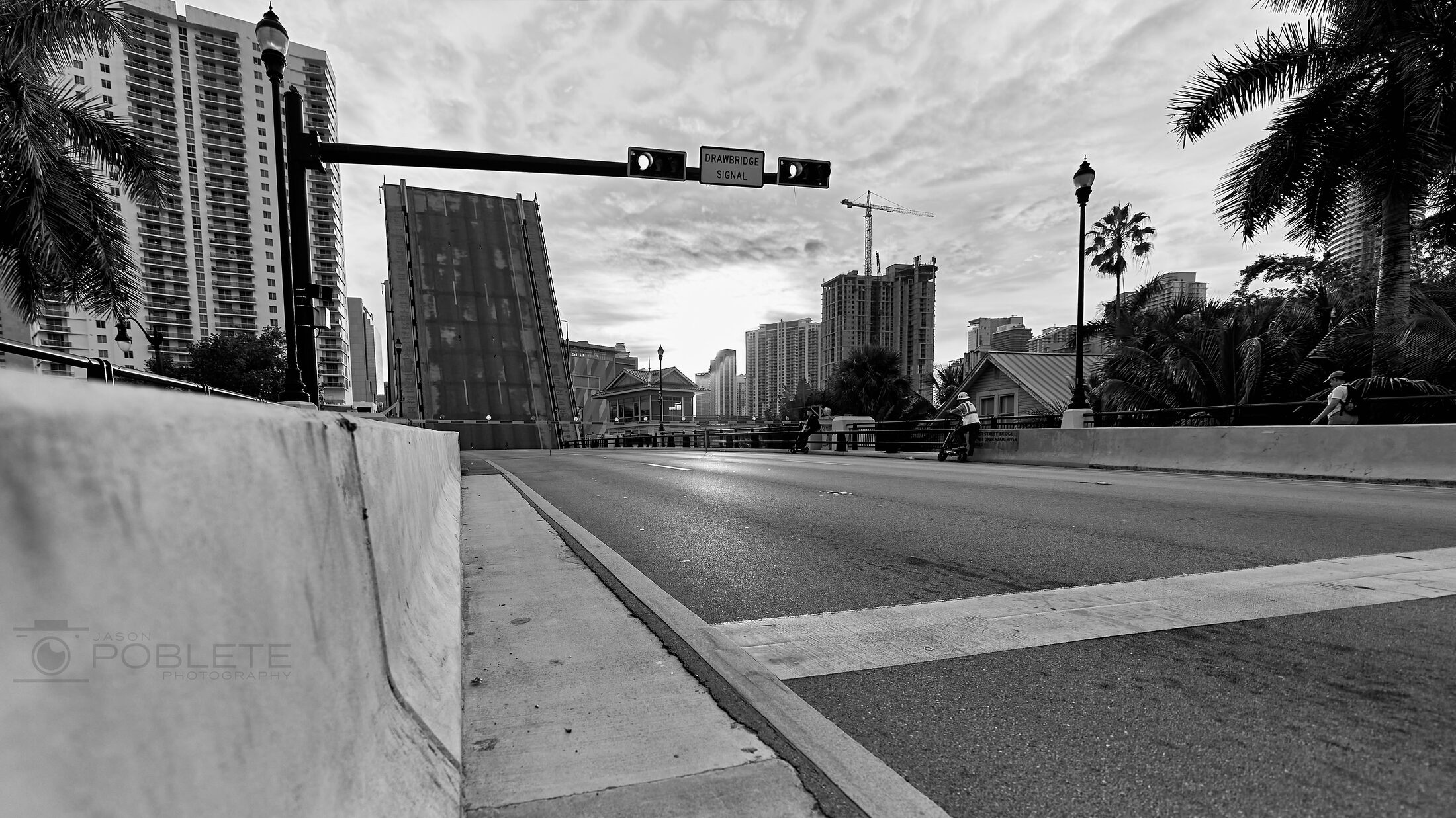 Hard sunlight divides a modern wall, ramp, and distant buildings.