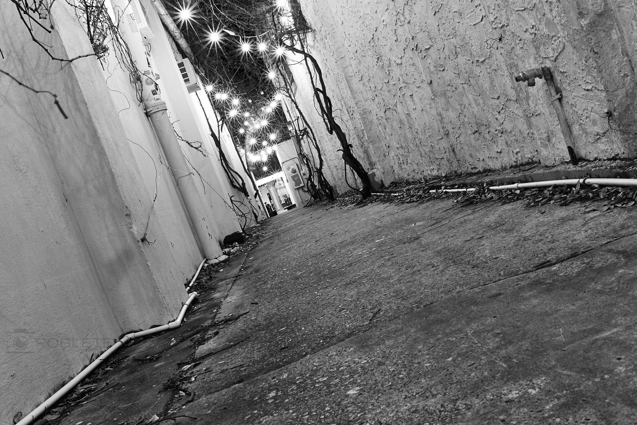 A tilted view looks through a narrow, weathered urban passage.