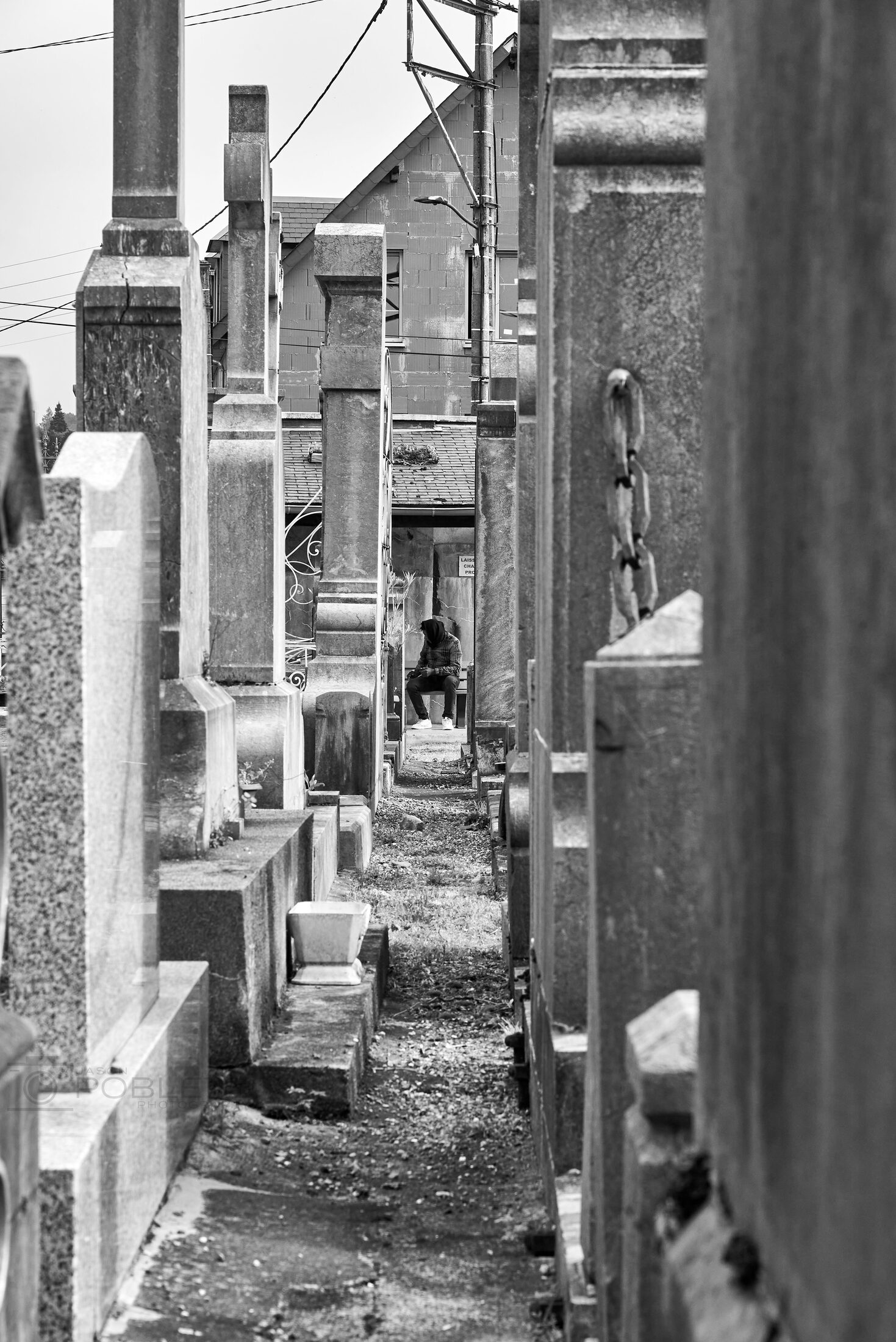 A narrow cemetery passage runs between rows of above-ground tombs.