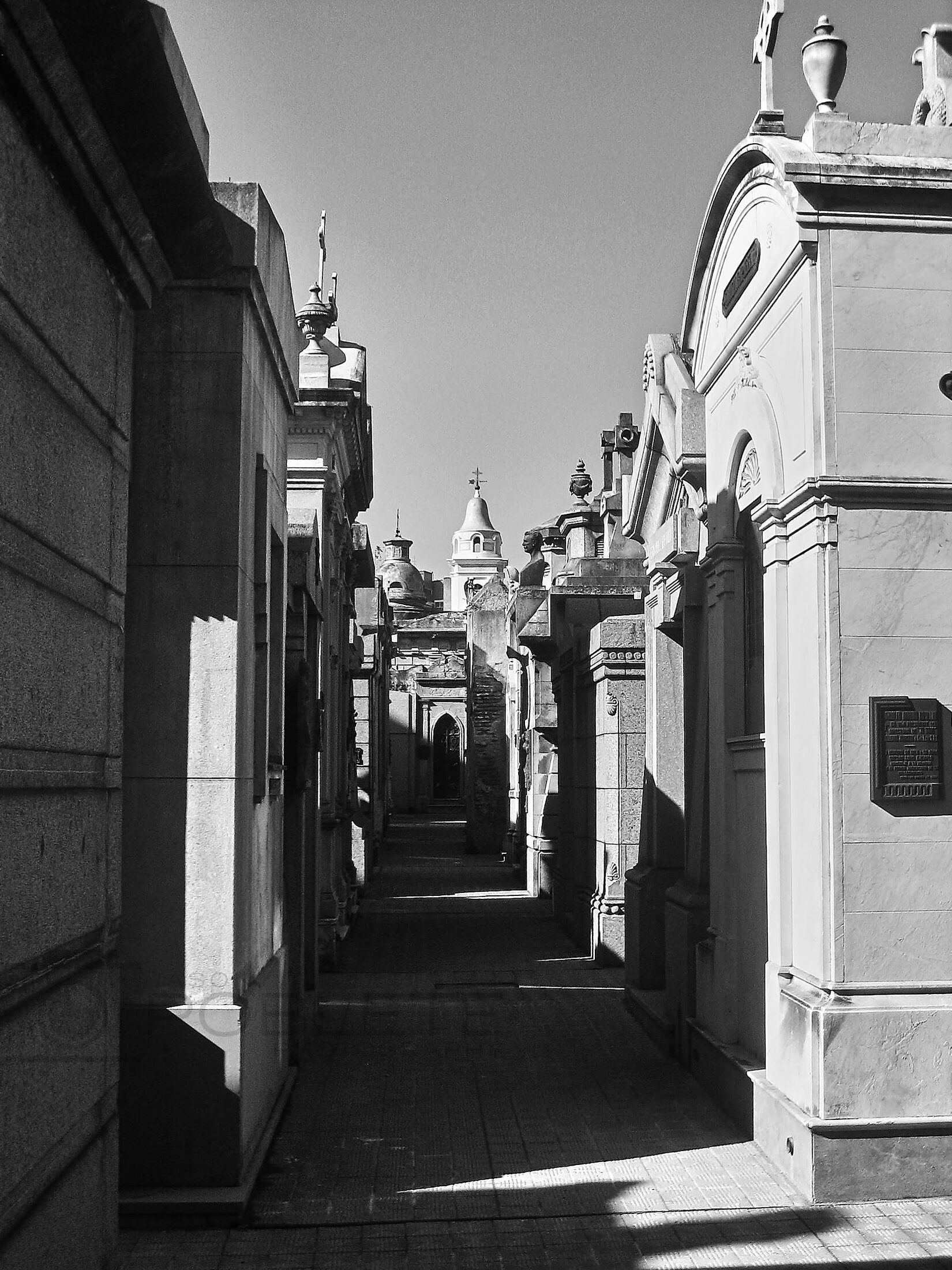 A narrow passage runs between ornate above-ground tombs.